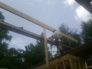 Carpenter setting a ridge beam over a new addition frame — Ice Dam Removal by Roofing Brothers in Brush
