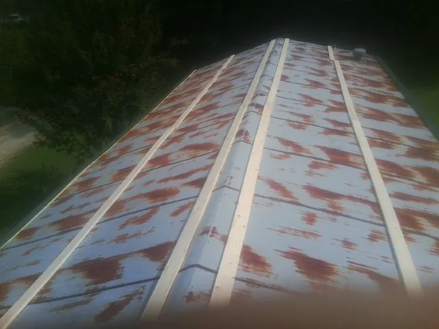 Rusted metal roof panels with new wood purlins before replacement — Storm Damage Roof Repair in Brush by Roofing Brothers