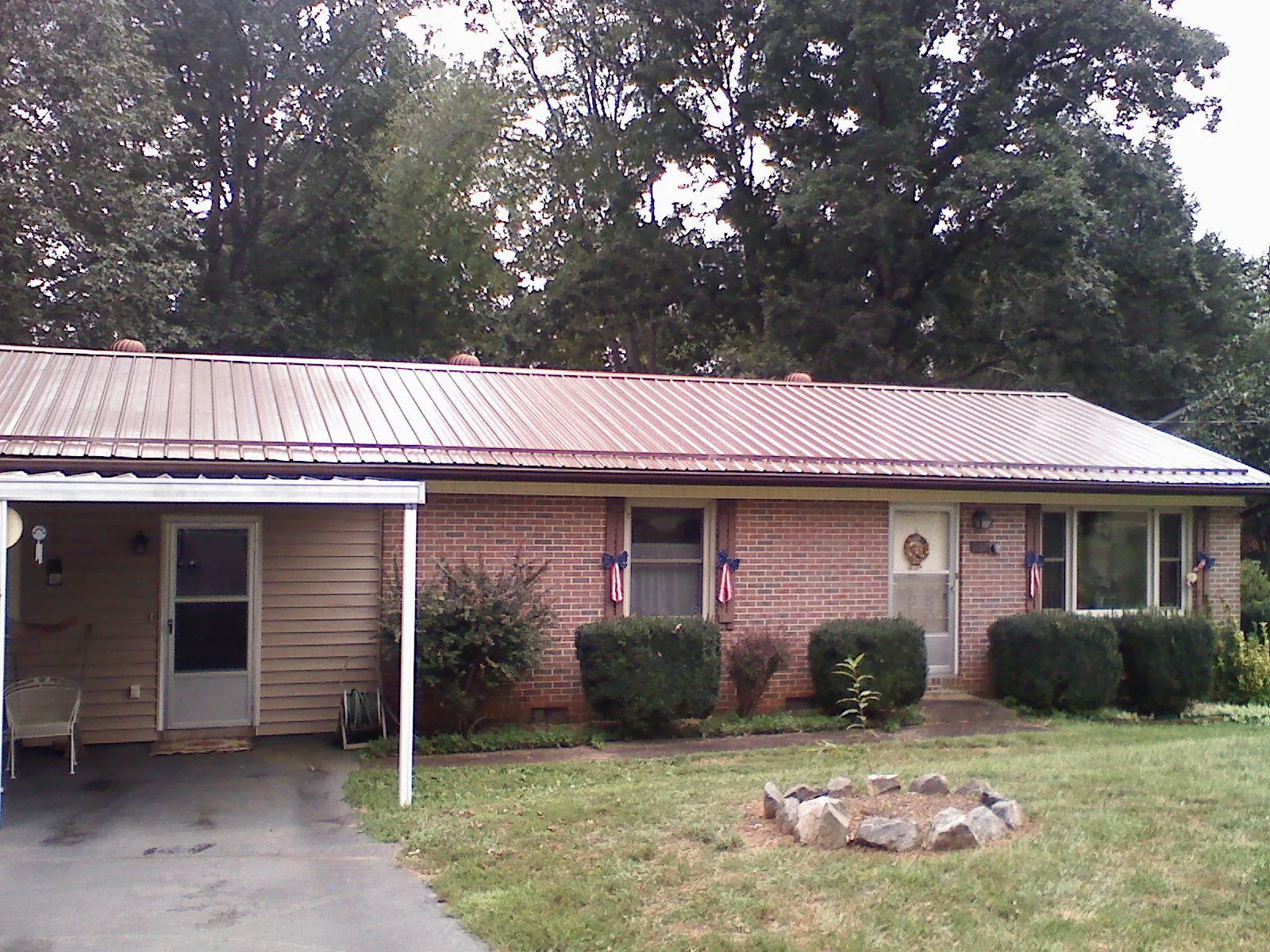 Bronze metal roof and carport on a brick ranch home — Roof Repair work by our crew in Brush